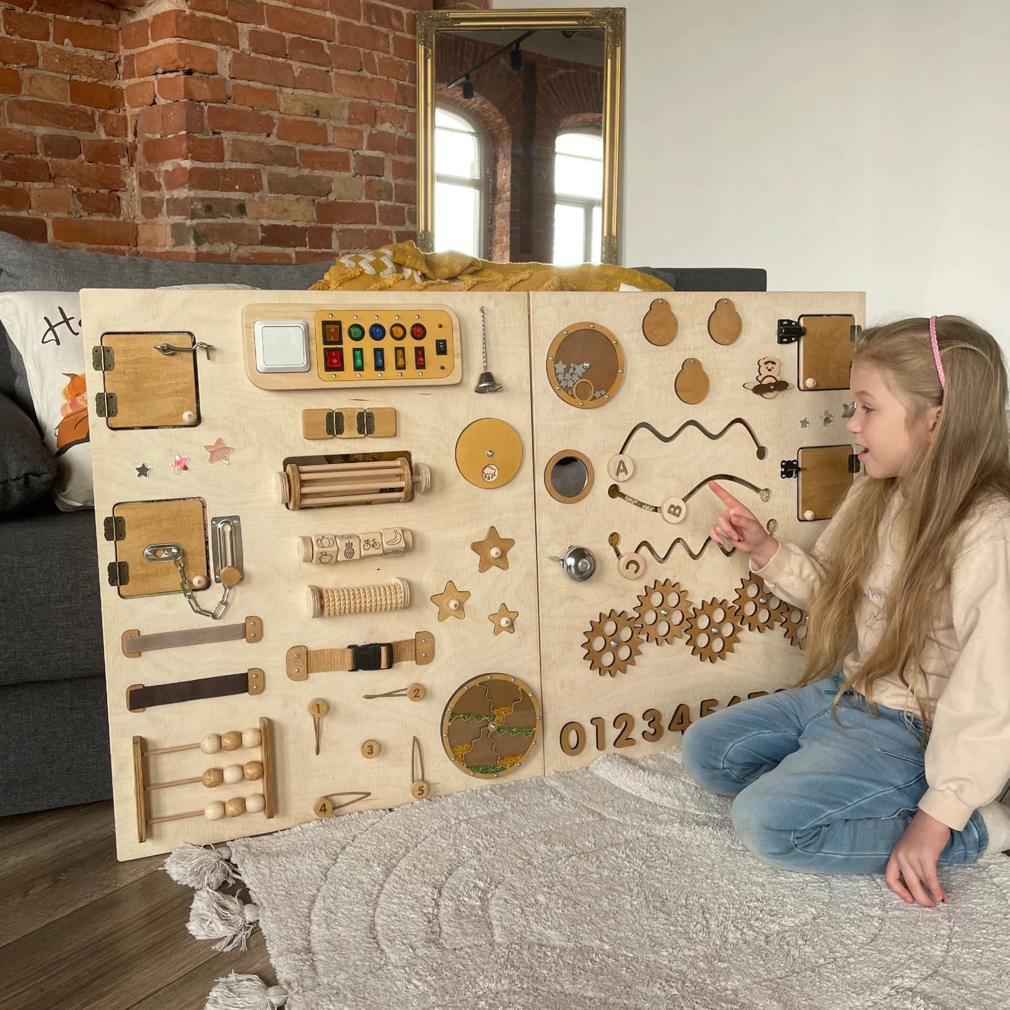 Girl interacting with natural-themed sensory wall panel featuring switches, gears, and tactile tracks. Encourages fine motor development, sensory regulation, and is perfect for autism, special needs, and therapy use