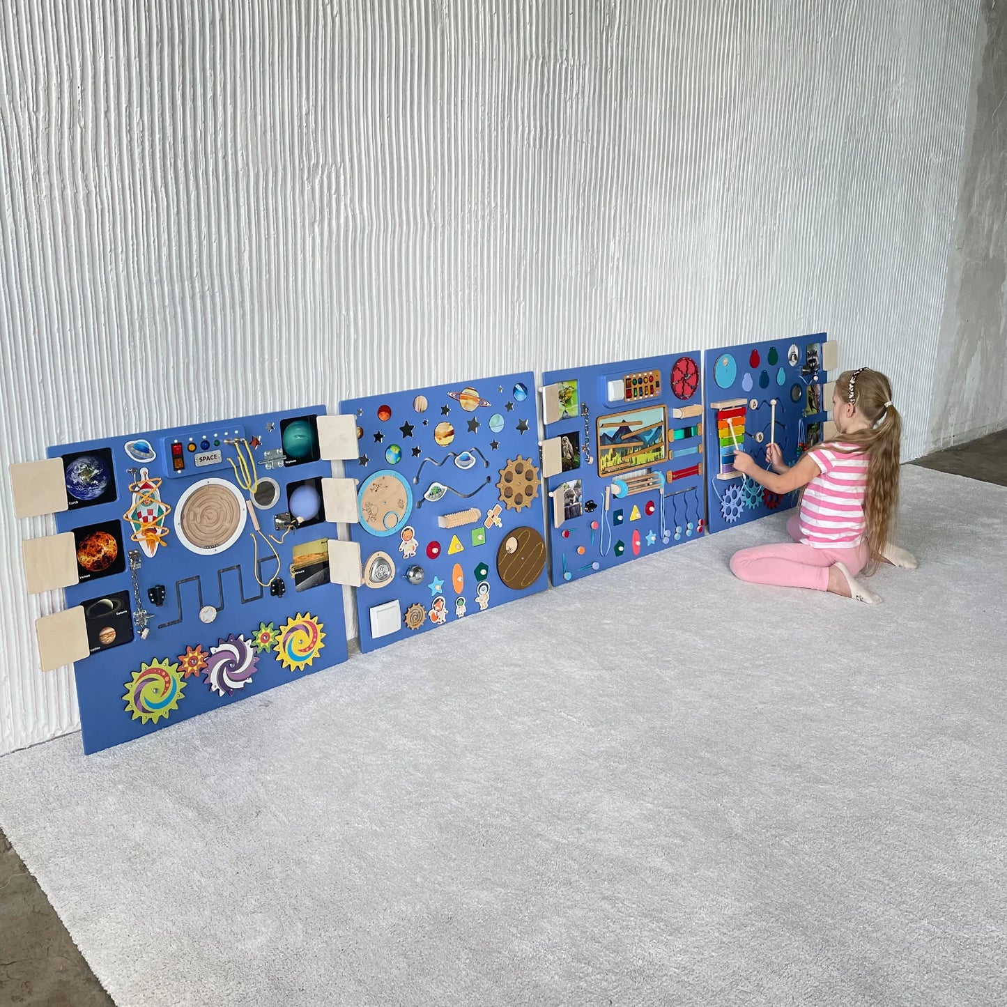Girl playing with an XXL sensory wall panel in deep purple color, featuring lights, gears, and Montessori elements, perfect for autism therapy and fine motor skill development