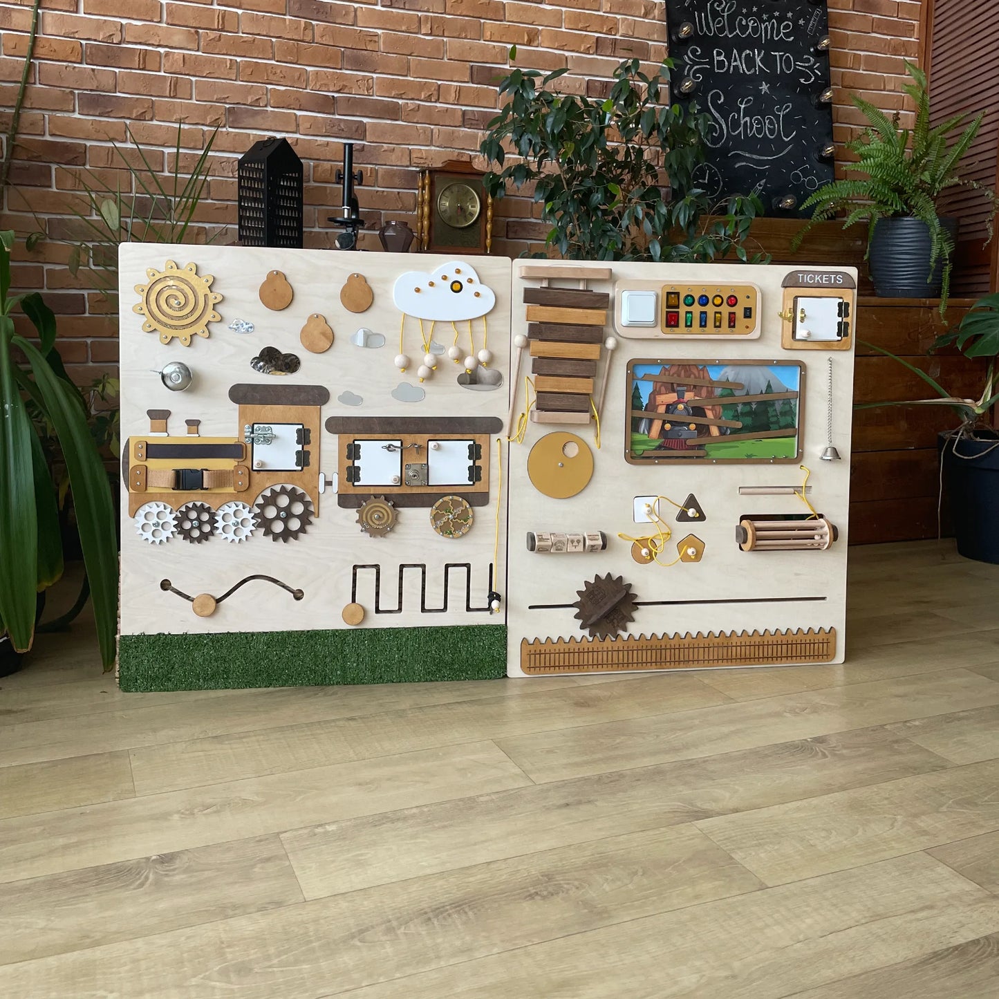 Wooden sensory wall panel in a train theme with interactive elements like gears, switches, locks, xylophone, and a mountain track maze. Ideal for schools and clinics