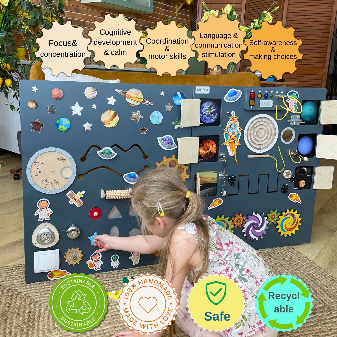 Dark grey sensory wall panel in space theme with a child interacting with elements. Icons highlight benefits: focus, calm, motor skills, communication, and self-awareness. Badges indicate sustainability, handmade quality, safety, and recyclability