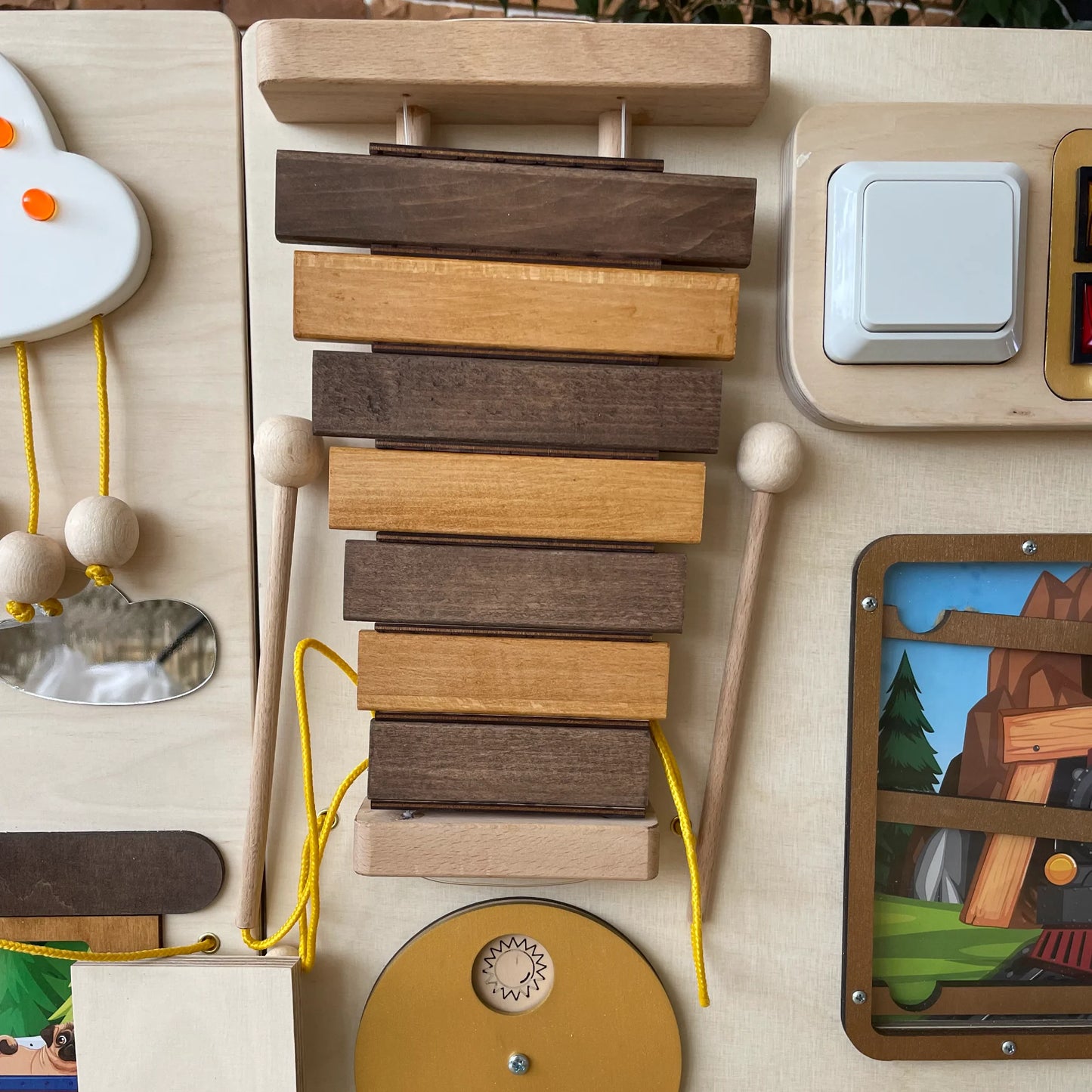 Wooden xylophone detail on train-themed sensory wall panel for classroom, clinic or autism therapy. Montessori-inspired tactile activity board with fine motor skill features