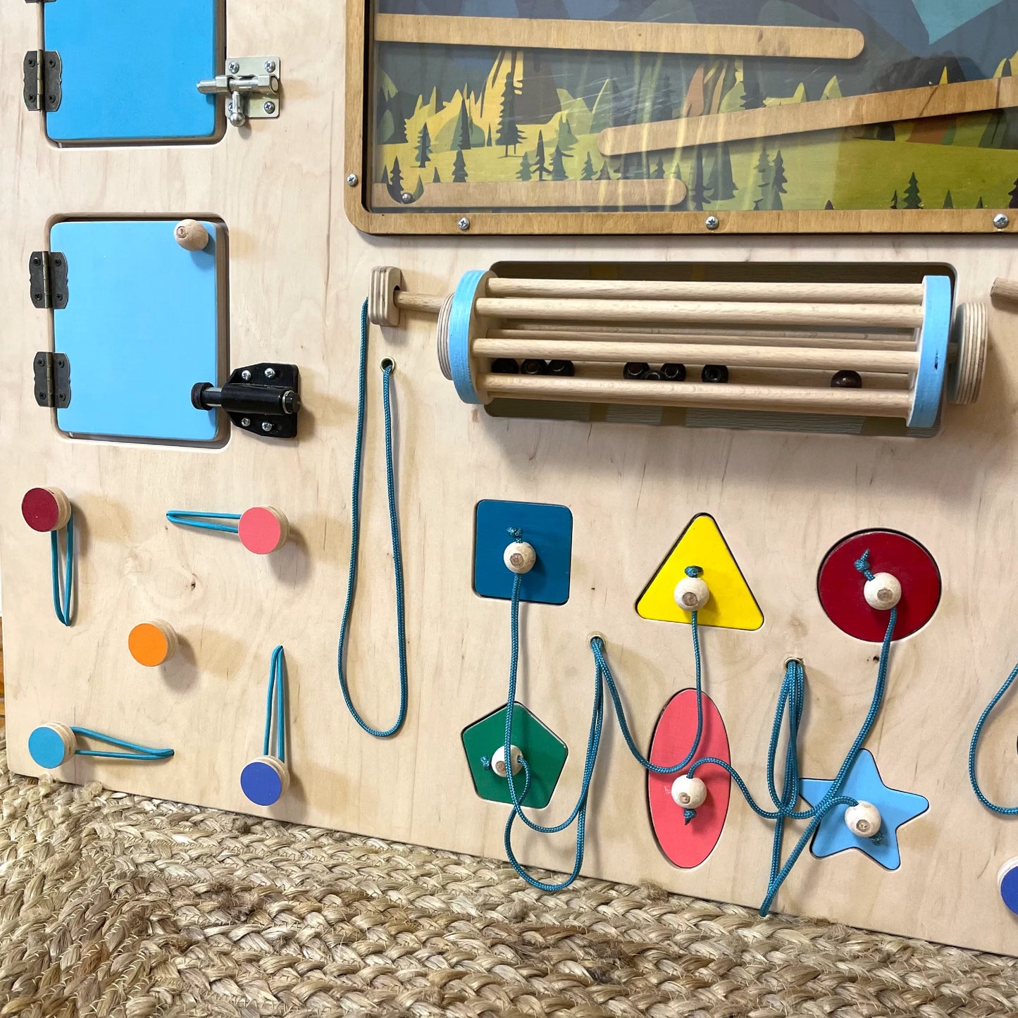 Lower part of sensory wall showing threading shapes, gears, laces, and rolling cylinder.