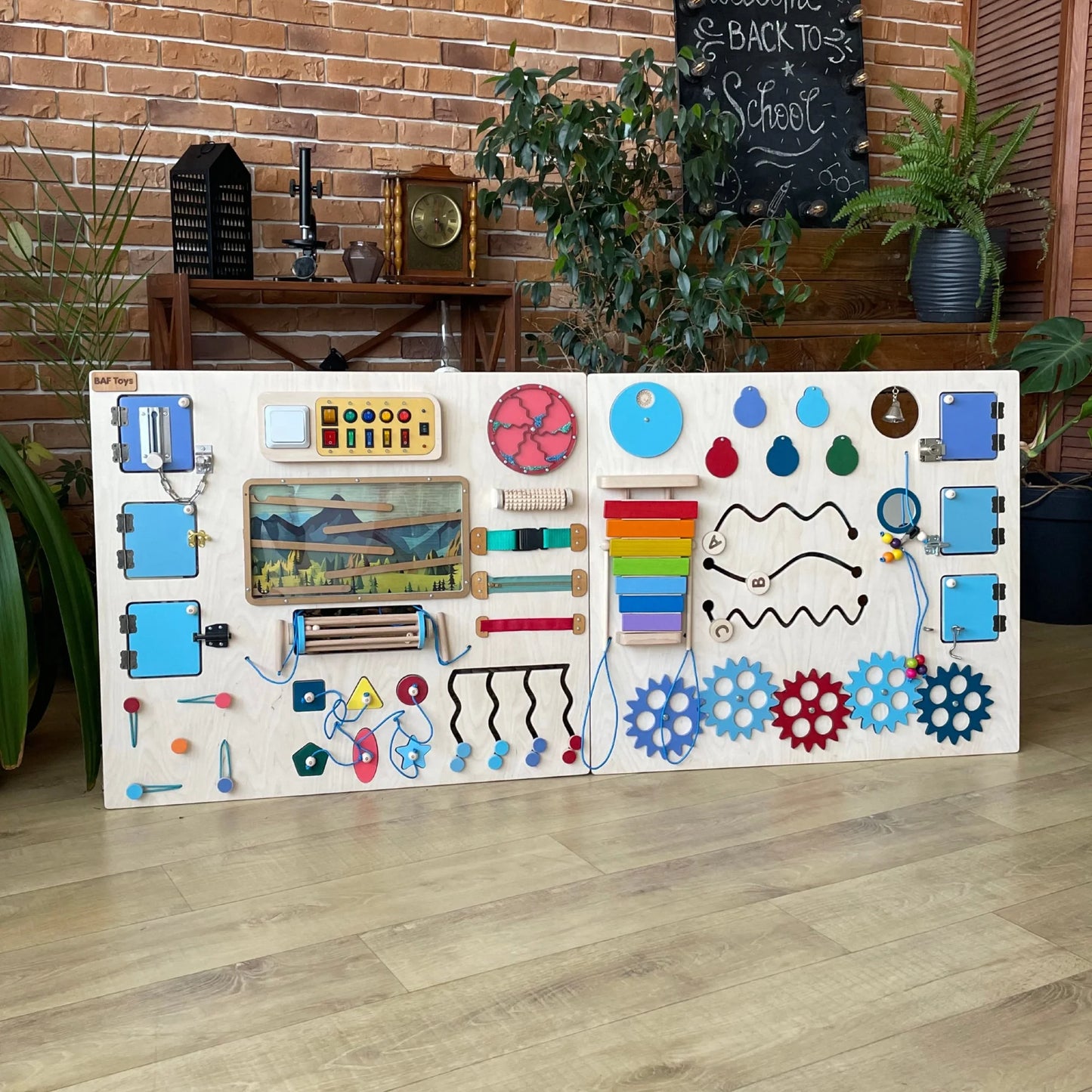 Front view of the sensory board in mountain theme with colorful lights, gears, xylophone, and interactive elements.