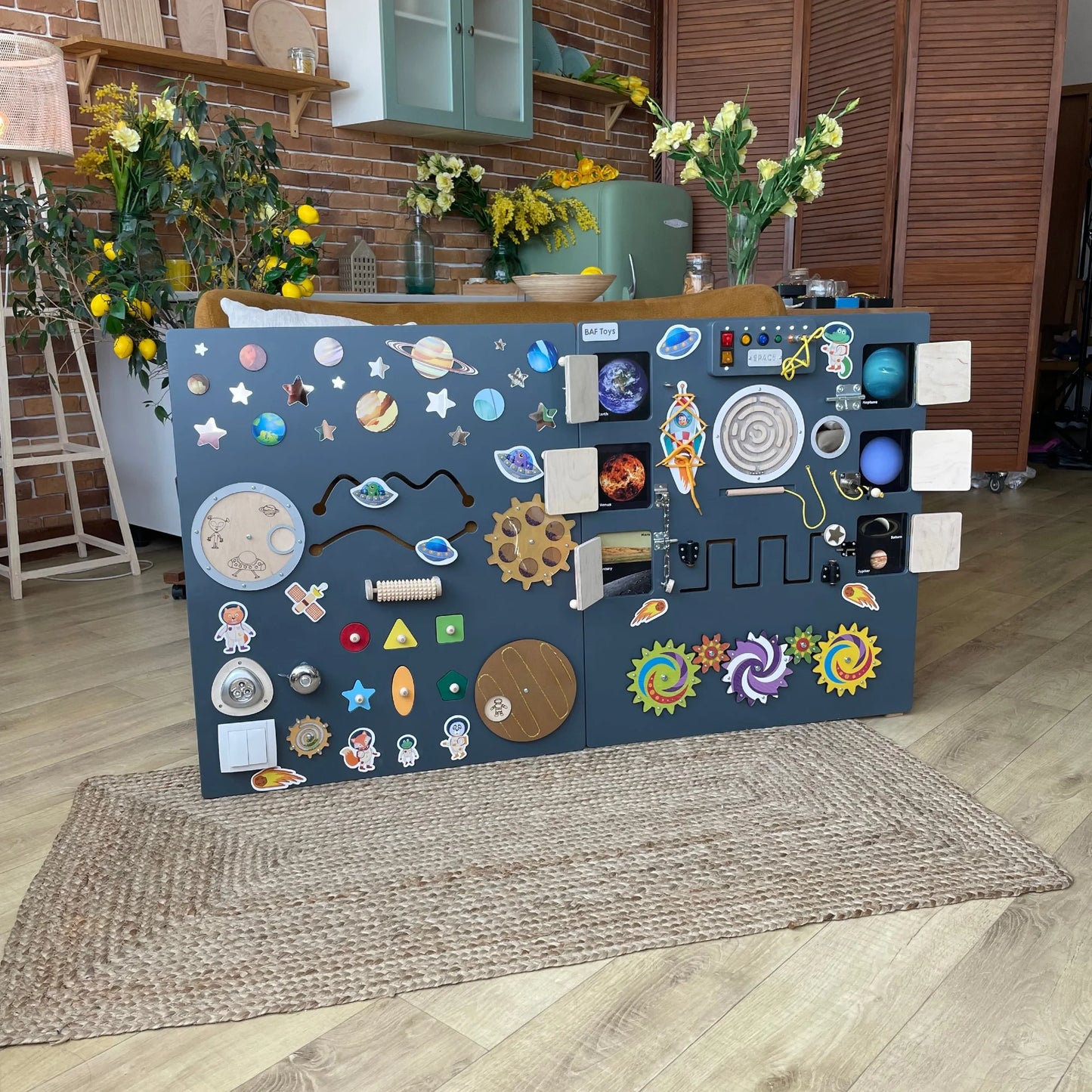 Dark grey space-themed sensory wall panel with switches, gears, tactile elements and lights. Designed for classrooms, autism therapy, and special needs
