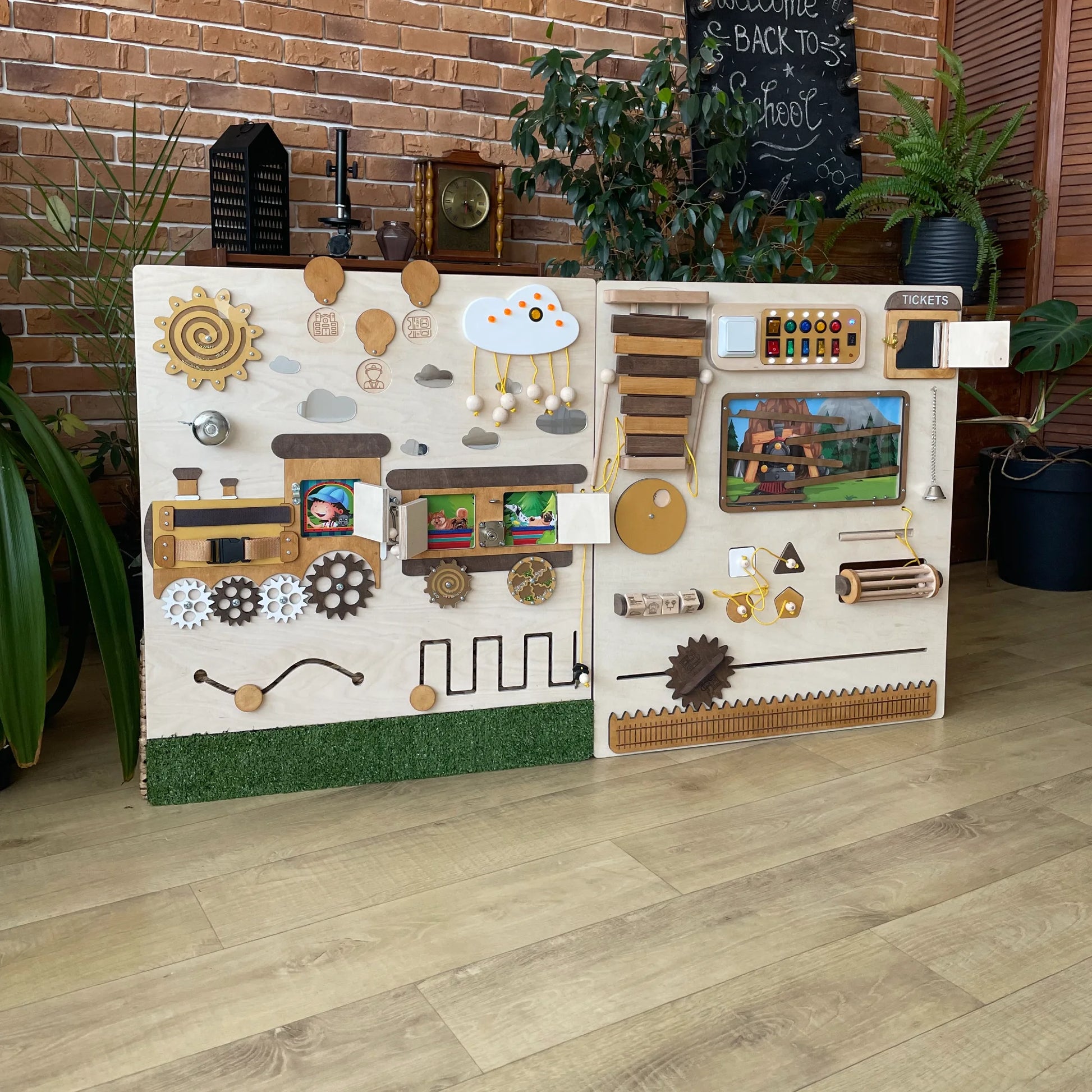 Interactive train-themed sensory wall panel with hidden photo windows, gears, lights, switches, a bell, and xylophone. Fun educational tool for schools and therapy spaces
