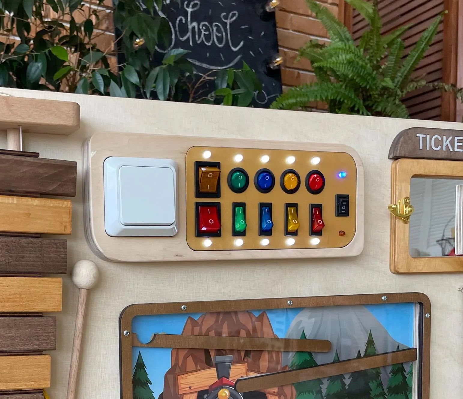 Close-up of colorful switches and LED lights on wooden train sensory wall panel for kids.