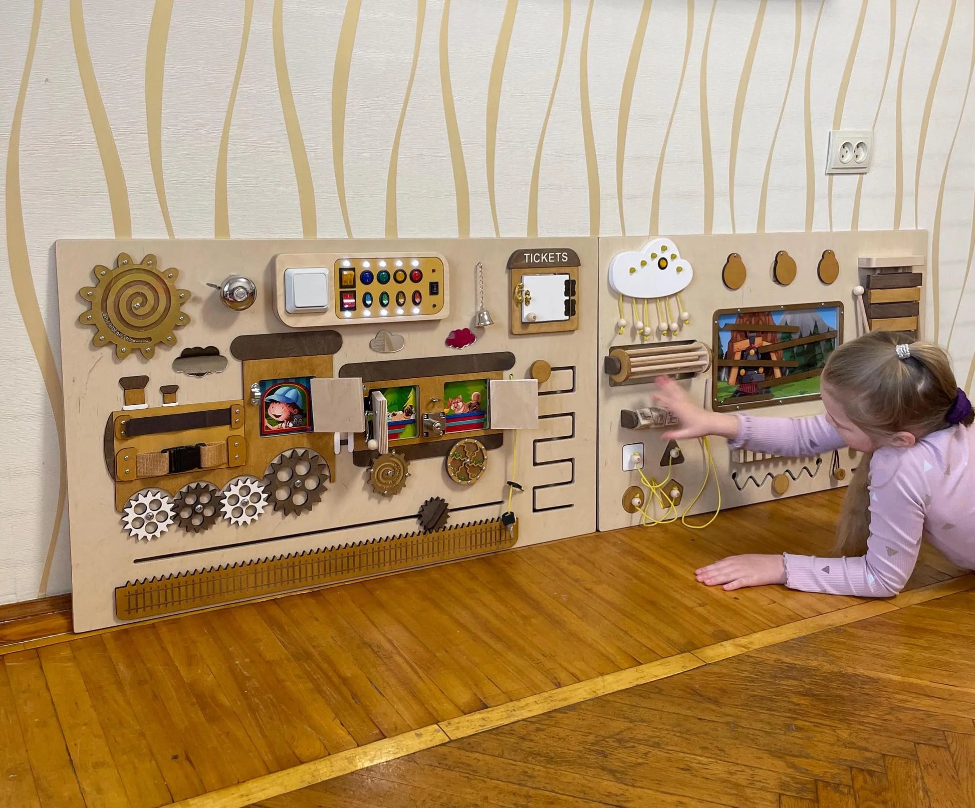 Child playing with train-themed sensory wall panel. Excellent fine motor skills toy for preschool sensory activity. 