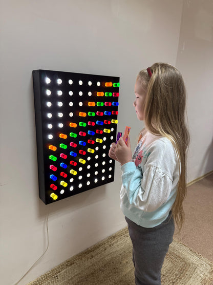 Girl placing green acrylic peg into Giant Light Peg Board With Acrylic Rods | Light Panel Sensory Wall – fine motor development sensory equipment
