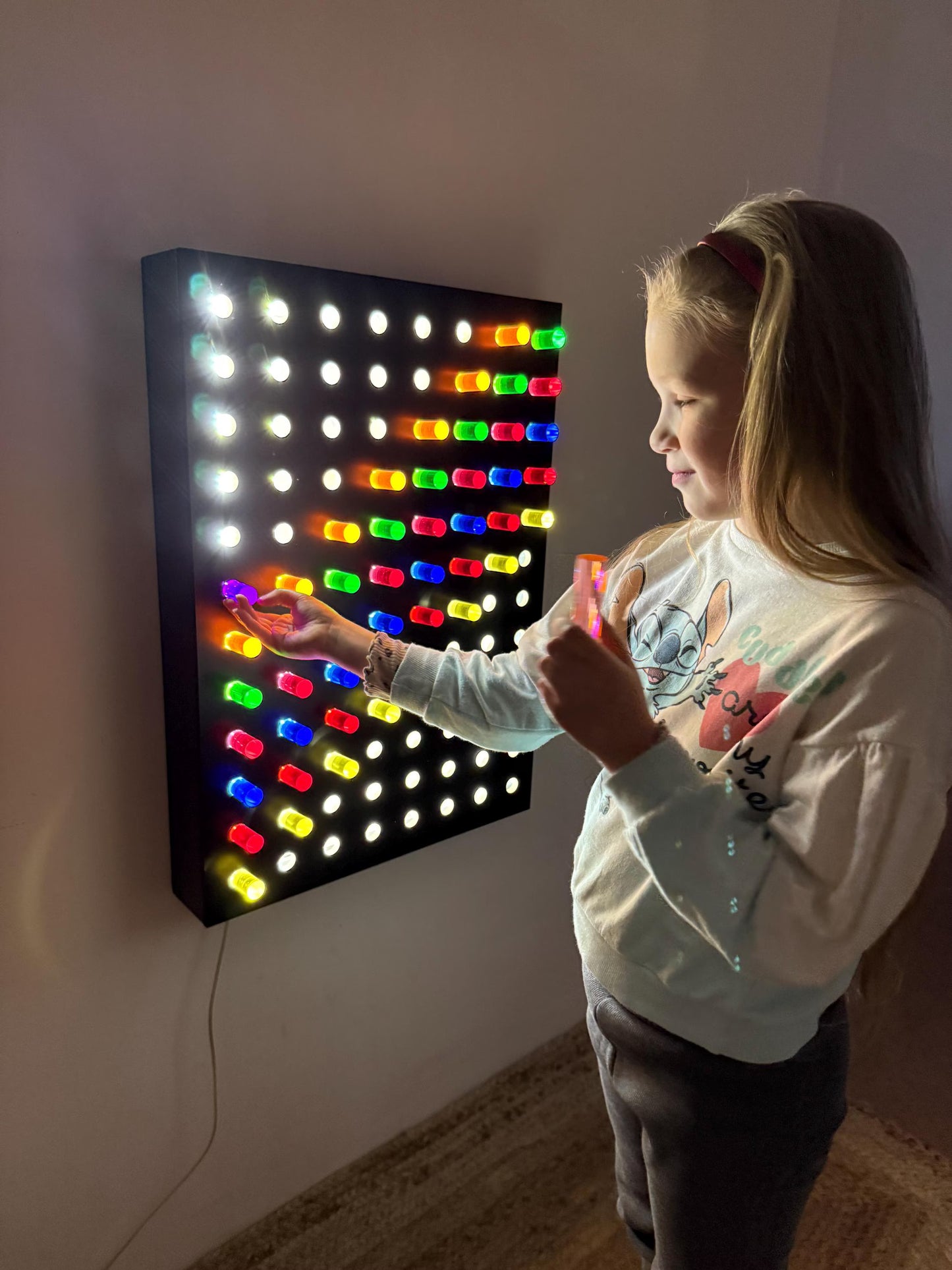 Girl interacting with Giant Light Peg Board With Acrylic Rods | Light Panel Sensory Wall in therapy room – sensory LED wall for autism and ADHD support
