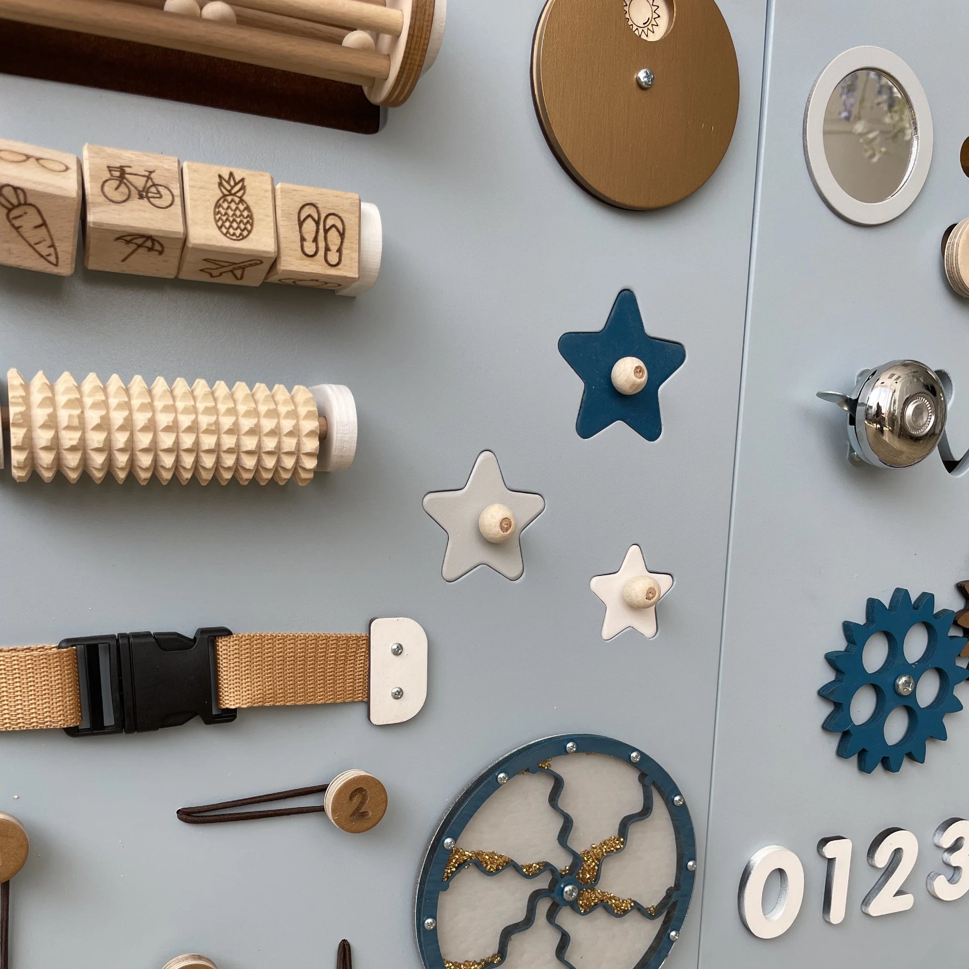 Sensory panel showing detailed lights, switches, and wood texture rollers for fine motor skill development
