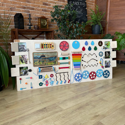 Activity board close-up showing flip photo doors with animal images like raccoon, woodpecker, and squirrel.
