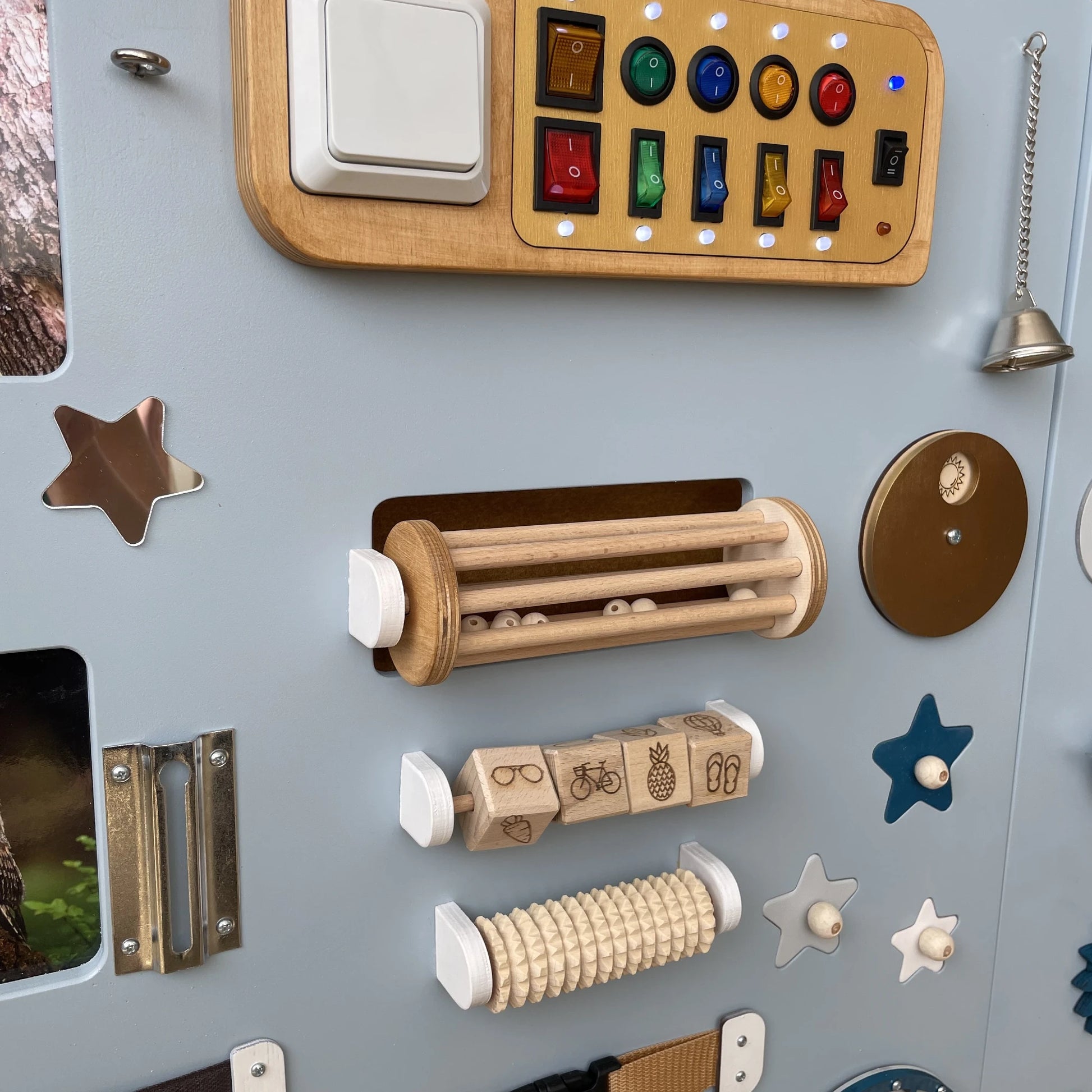 Left side close-up of sensory panel showing belts, rollers, abacus and wooden doors
